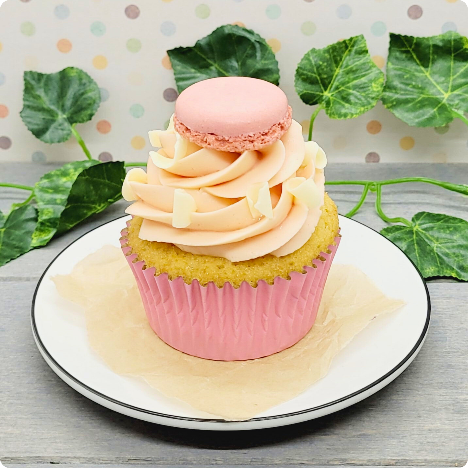 Close-up van Berry White Cupcake met witte chocolade en aardbeien botercrème, afgewerkt met een macaron.