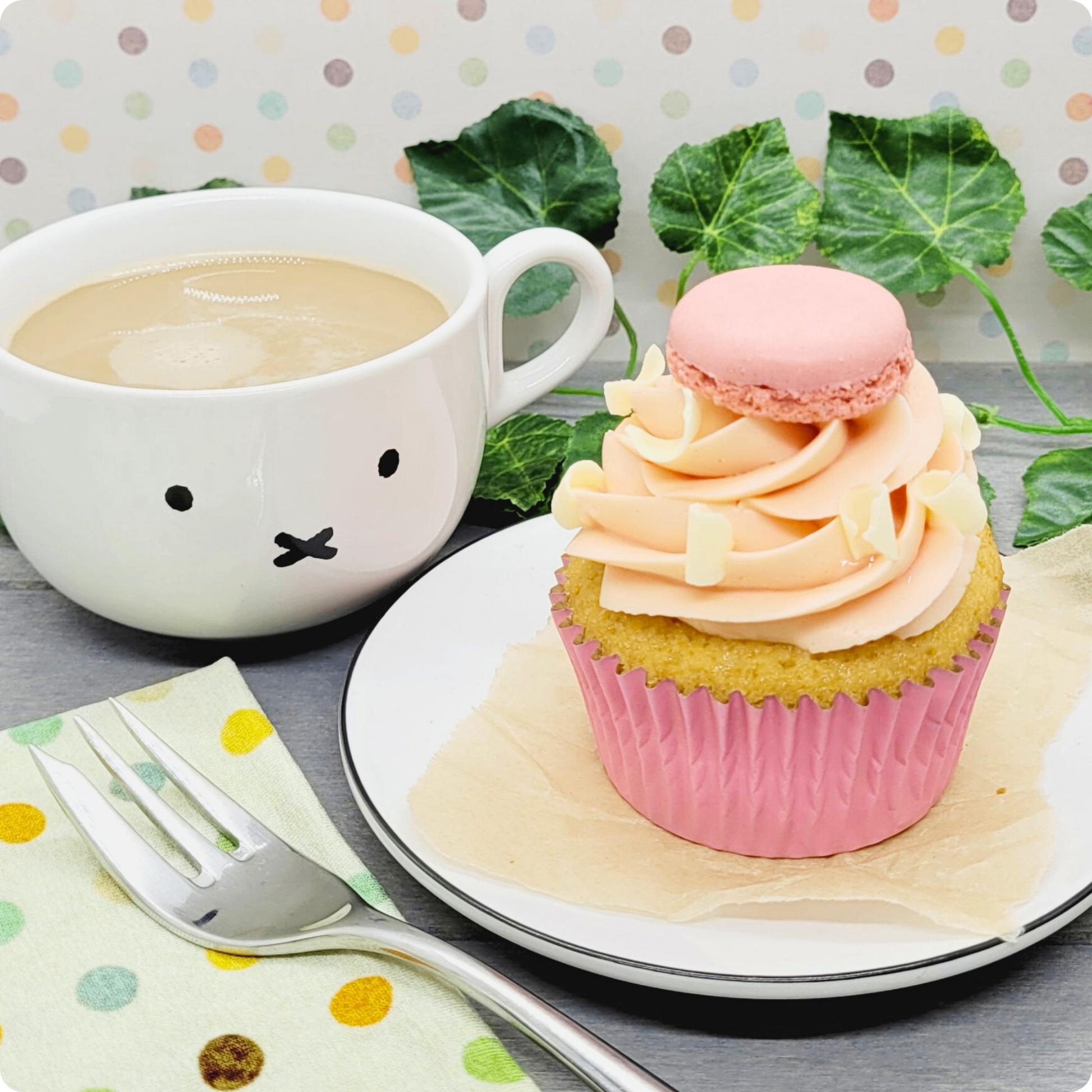 Berry White Cupcake geserveerd op een bord met koffie, de ultieme zoete traktatie.