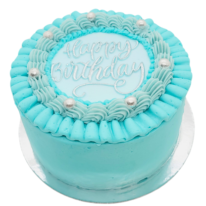Mini cake in pastelblauw met zilveren “Happy Birthday” tekst en zilveren parels