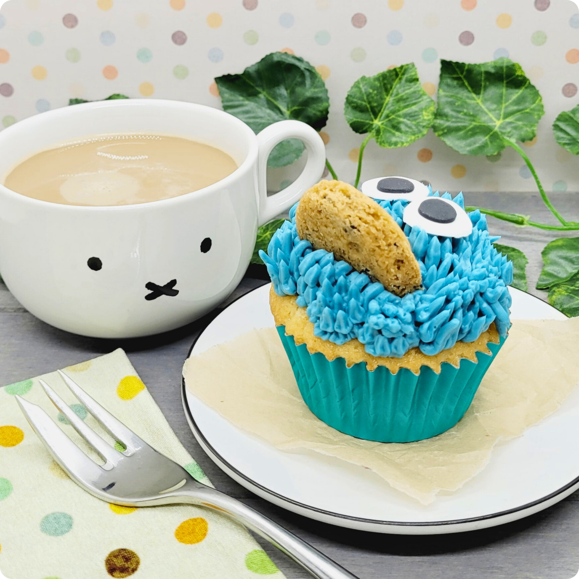 Speelse cupcake met blauwe botercrème en chocolate chip cookie, geserveerd met koffie.