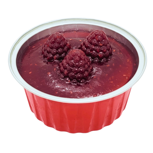 Bovenaanzicht van een mini New York cheesecake in een rood bakje met frambozen gelée