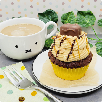 Snickers Cupcake geserveerd op een bord met koffie, een match made in heaven!