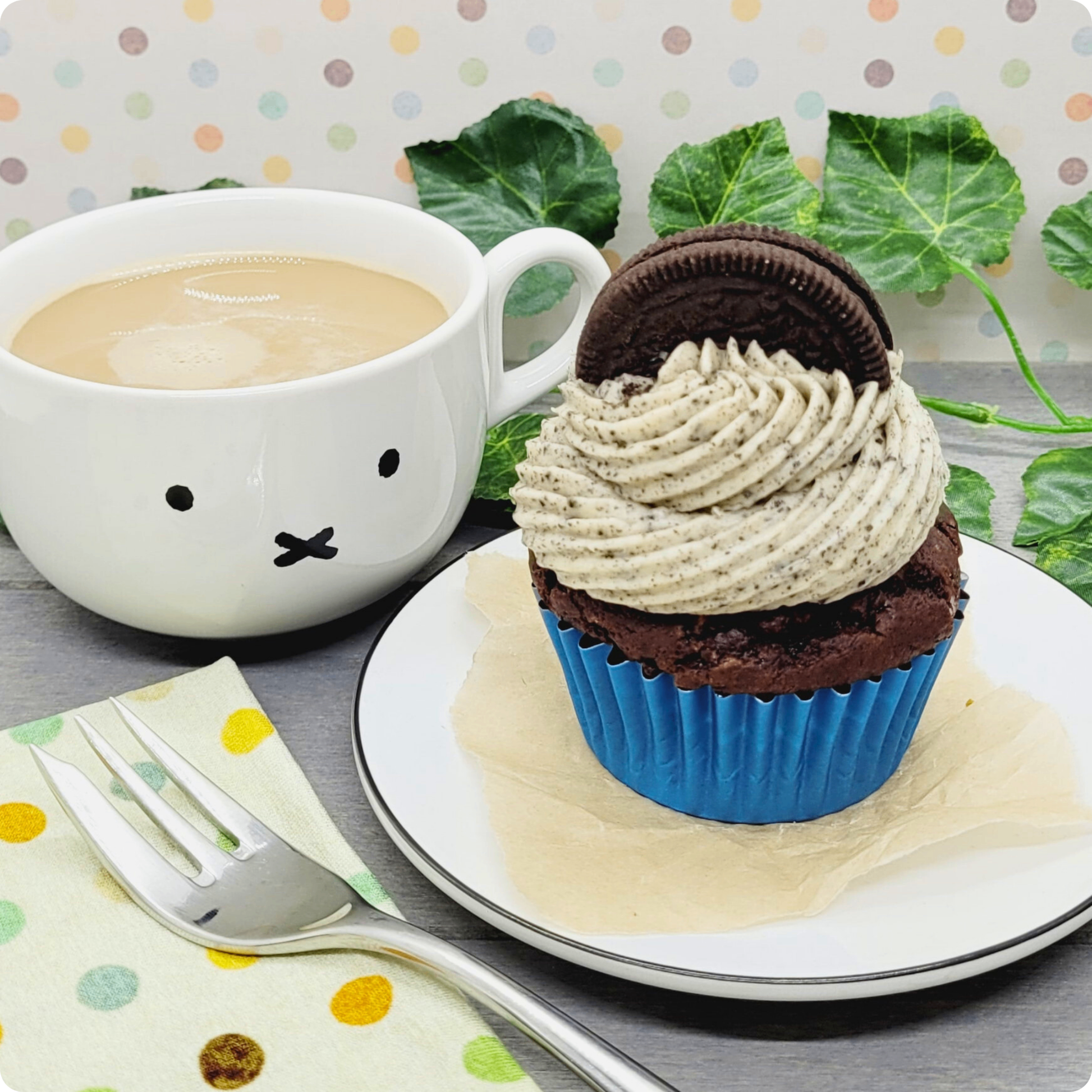 Vegan Oreo Cupcake geserveerd op een bord met koffie, een match made in heaven.